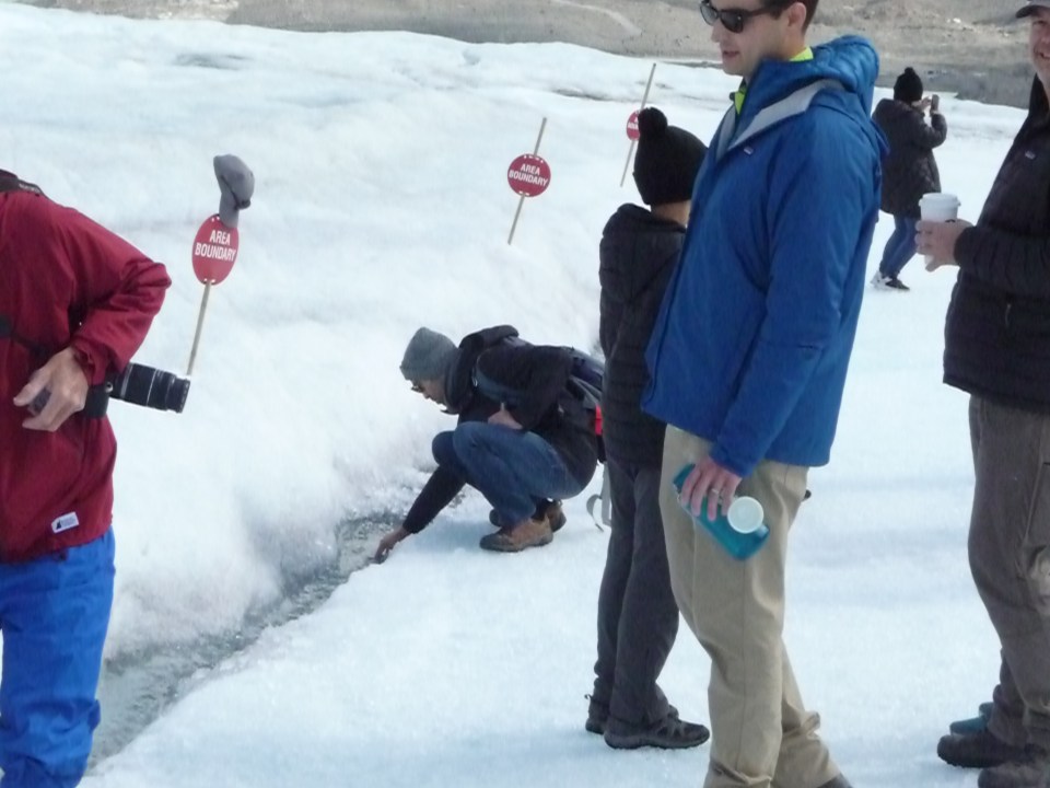 Collecting water from the melting Athabasca Glacier for a cool drink, Canada.
