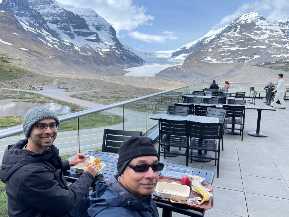 Enjoying a much needed lunch on the patio after the walk on the Athabasca Glacier with the mountain range and glacier in the background, Canada.